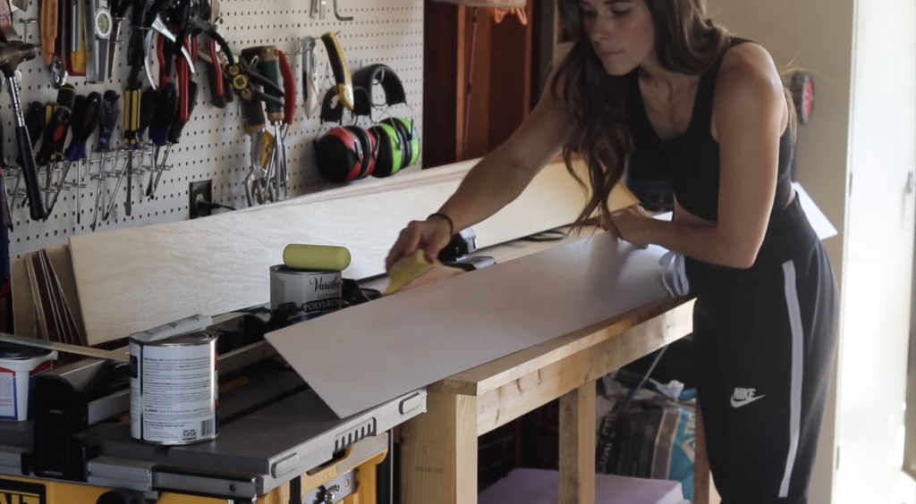 Sanding down the boards to give them a satin sheen 